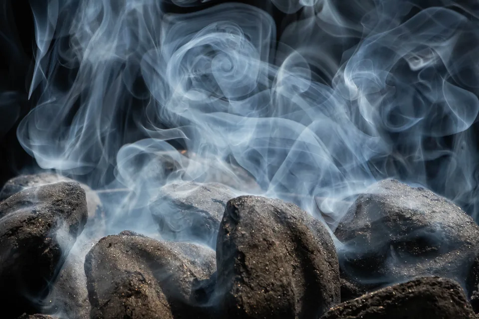 Partagas D4 Review (Serie D No. 4) — pale blue wisps of smoke swirling above dark smouldering coals