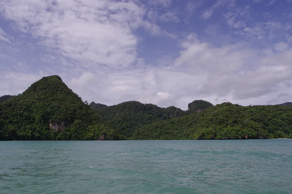 Cigar Langkawi: Is the Island Still Duty-Free for Cigars? — forested limestone islands rising from calm sea under clouds in Langkawi
